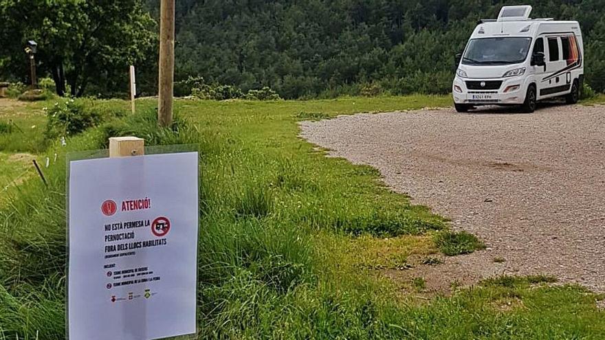 Una autocaravana aparcada en una zona on un cartell informa de la prohibició de pernoctar-hi