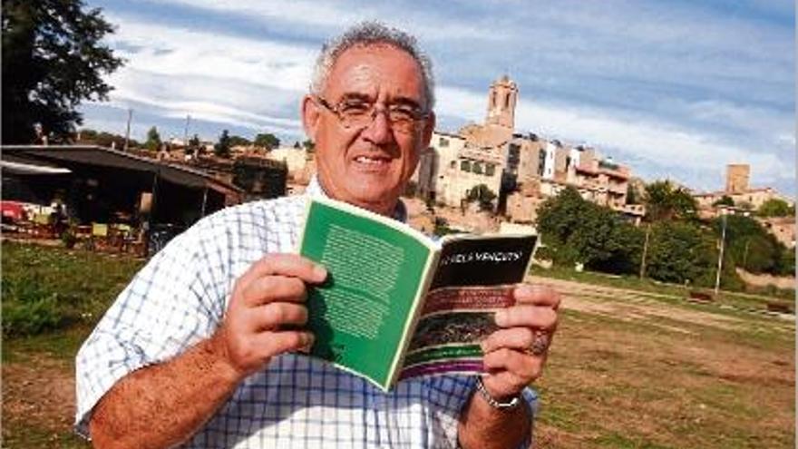 Josep Manuel López Gifreu, amb el llibre al davant i el poble de Colomers al fons.