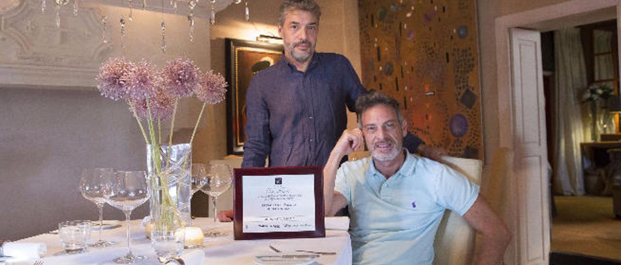 A la izquierda, el chef Eric Bisschop junto a Alexandre, sentado, enseñan el Premio Mejor Restaurante 2016.