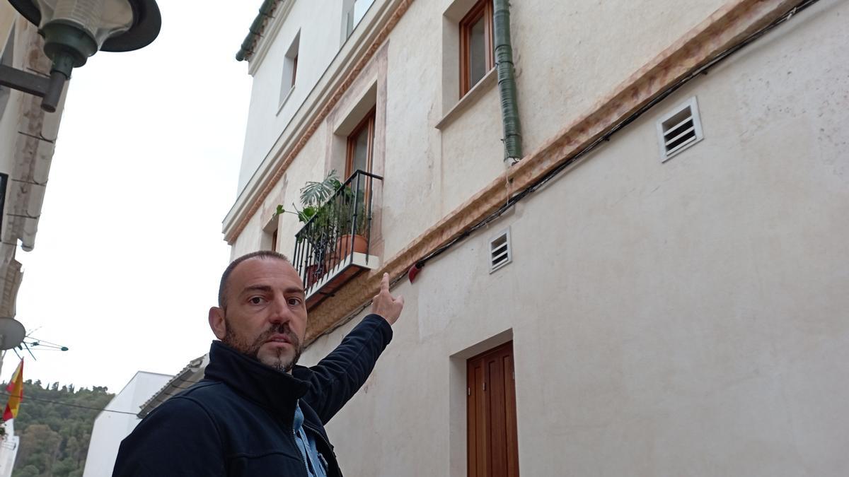 Jorge Cáceres señala la ventana que elevó, en una zona con pinturas murales.