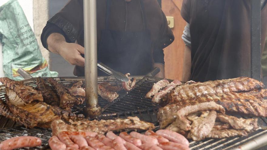 Carne y chorizos asados, alimentos con colesterol malo, en una fiesta popular.