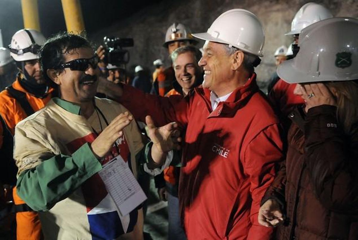 El miner Juan Illanes, a l’esquerra, saluda el president de Xile, Sebastián Piñera, després de ser rescatat. Illanes ha estat el tercer a sortir de la mina.