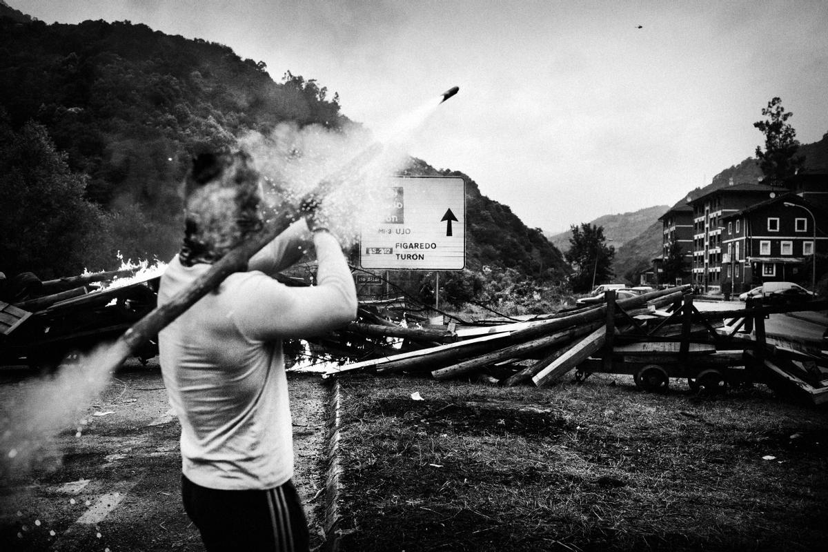 Un minero de carbón dispara cohetes contra un helicóptero antidisturbios de la Guardia Civil durante los enfrentamientos en la puerta de la mina Pozo Santiago en Caborana, cerca de Oviedo, al norte de España, el 6 de julio de 2012. Los mineros protestaban contra la propuesta del gobierno de disminuir los fondos para la producción de carbón. 