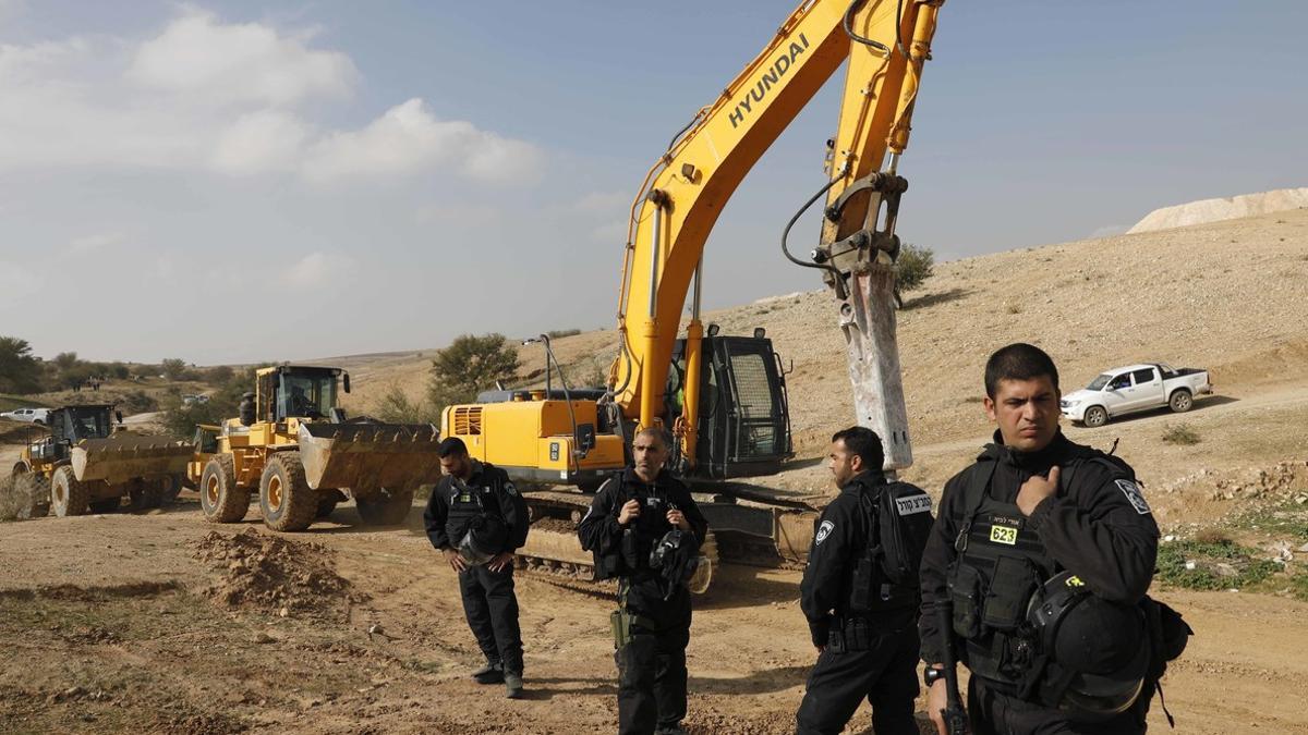 Policías israelís montan guardia junto a excavadoras tras demoler las casas del poblado beduino de Um al Hiran, este miércoles.
