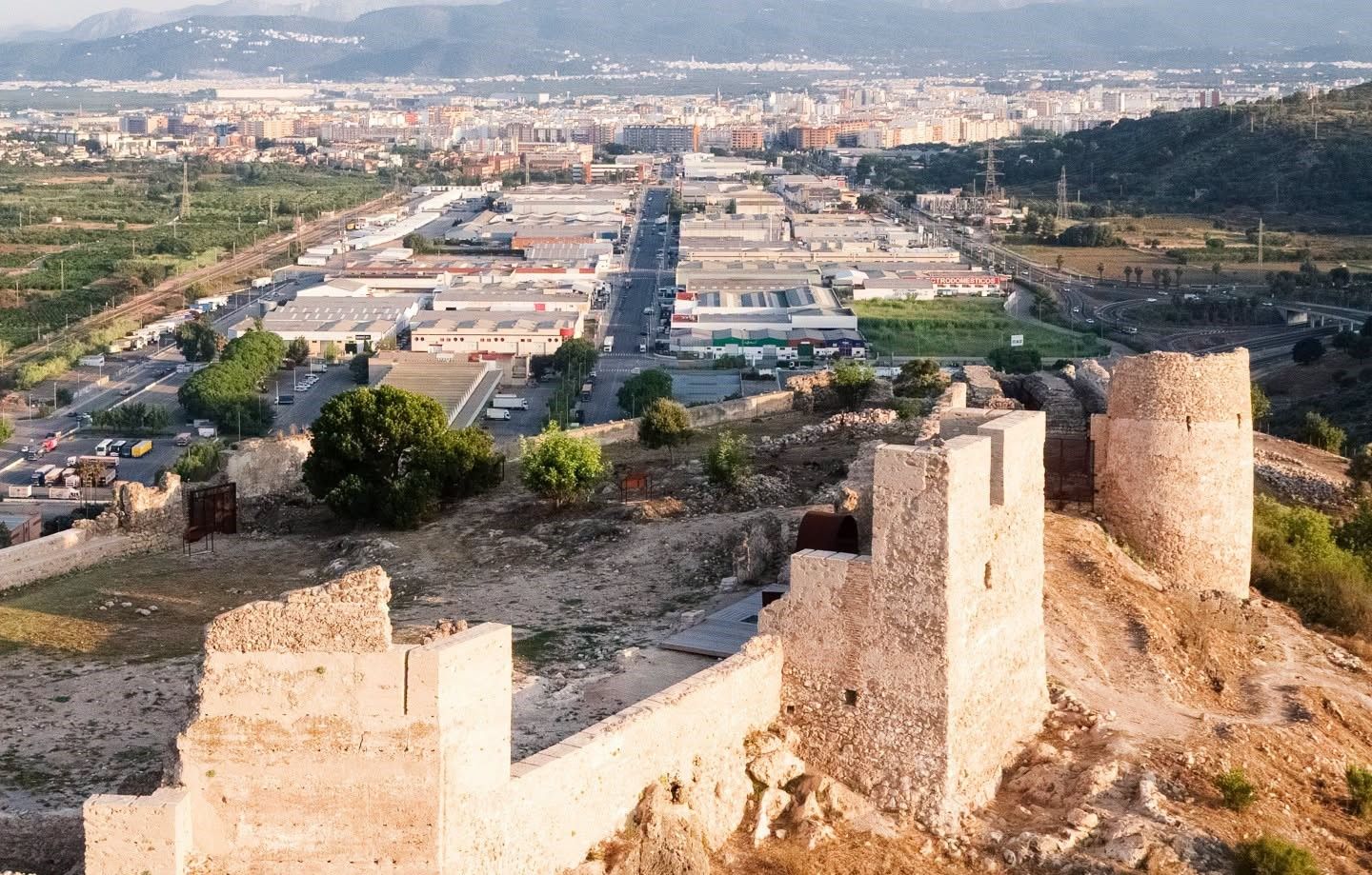 Vista del polígono Alcodar de Gandia con el castillo de Bairén en primer término.