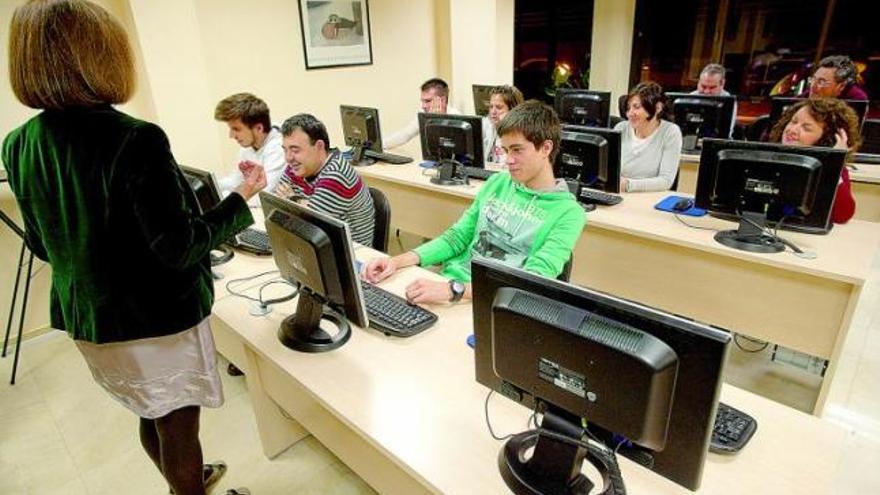 Un grupo de alumnos y su profesora, en el aula de informática de una academia avilesina.