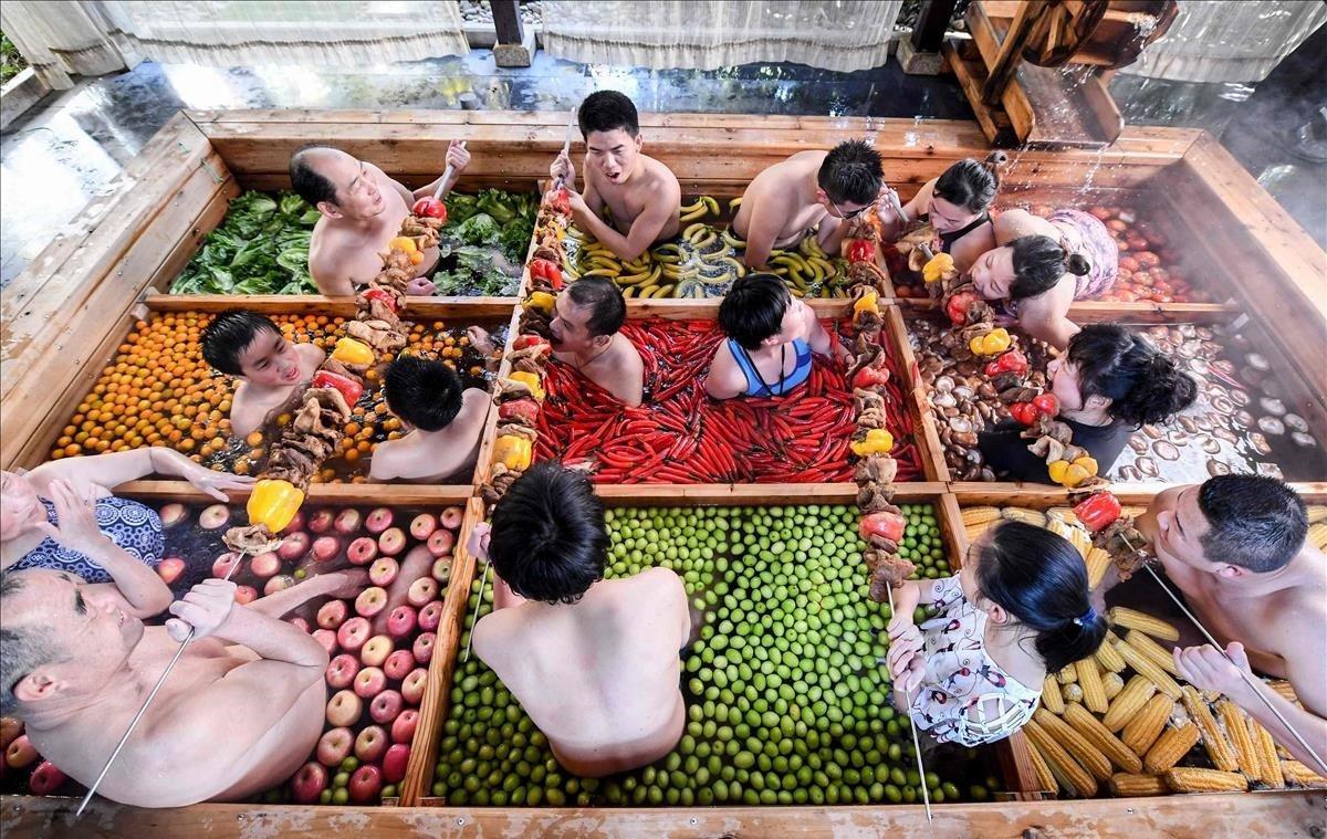 Diversas personas disfrutan de un chapuzón en una piscina de aguas termales entre frutas y vegetales en un hotel en Hangzhou, en la provincia china de Zhejiang.