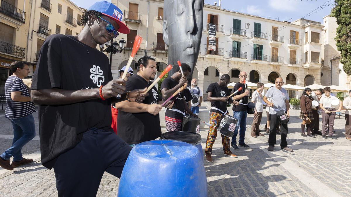 Un grupo de personas extrajeras en la plaza Major de Gandia durante un acto reivindicativo de Cáritas.