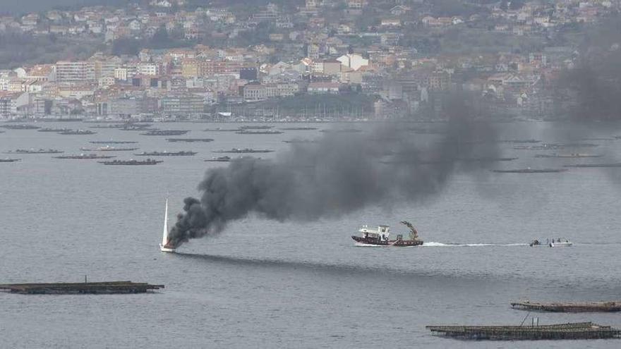 El velero, ayer, en llamas y envuelto en humo en la ría de Vigo frente a Moaña. // R. Grobas