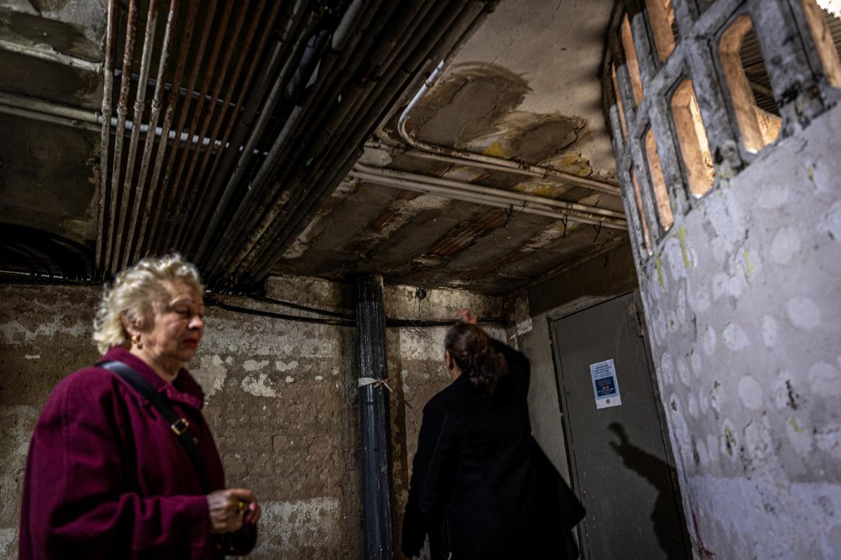 Una vecina en una portería afectada por las humedades de la calle Venus, en el barrio de La Mina, en Sant Adrià de Besòs.