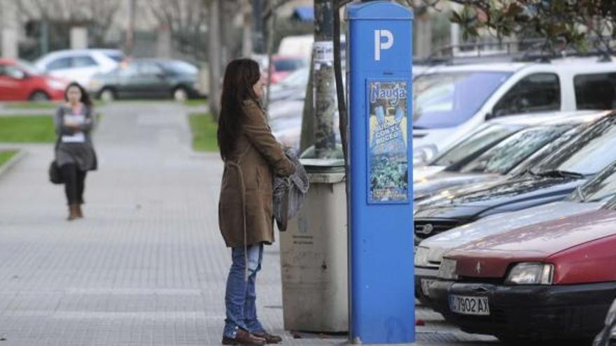 Una mujer abona la tarifa de la ORA en una máquina expendedora situada en el centro de la ciudad. / fran martínez