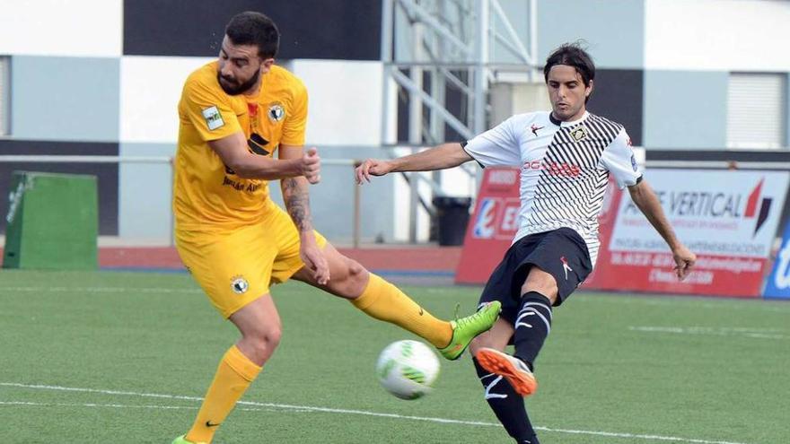 David González despeja el balón ante el delantero del Burgos Adrián.