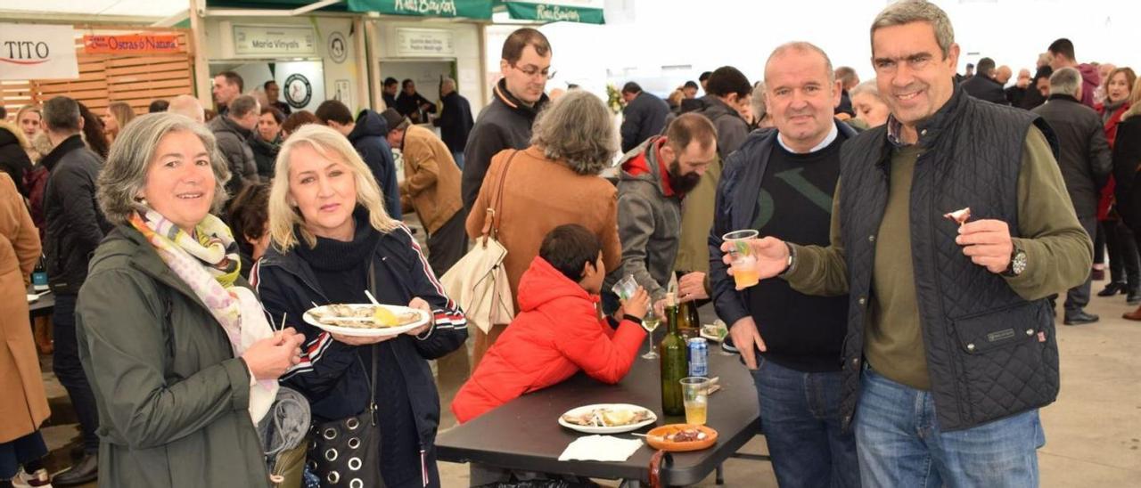 Unas personas disfrutan de las ostras, ayer, durante la primera jornada de la fiesta gastronómica.   // C.S.