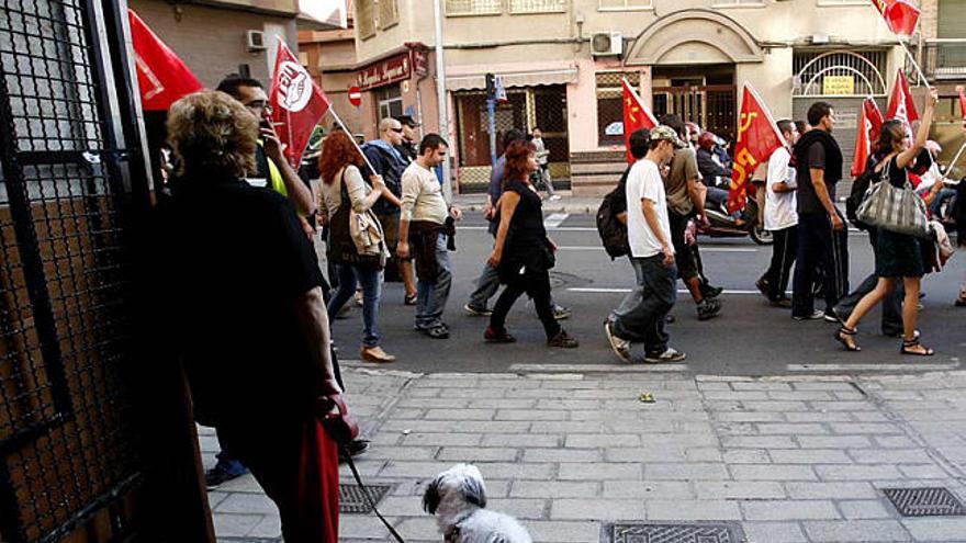 Una columna de sindicalistas pasa por una calle de Alicante ante la mirada de los ciudadanos.