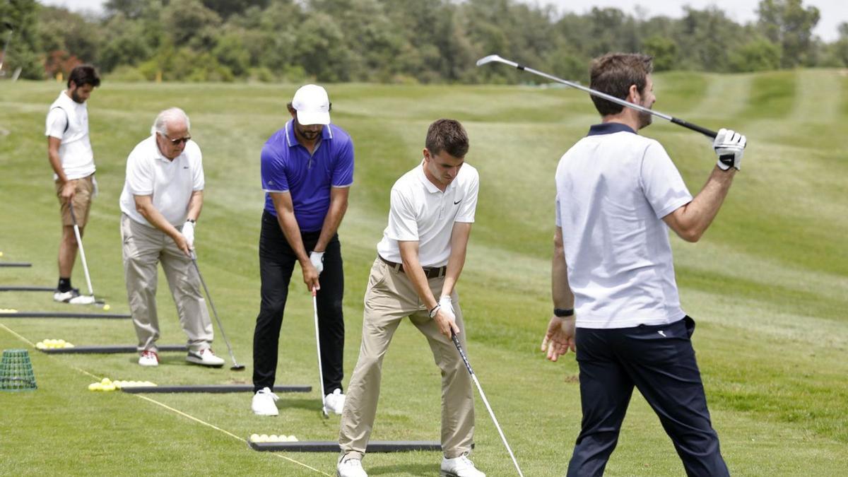 Jugadors practicant en un camp de golf. | ANIOL RESCLOSA