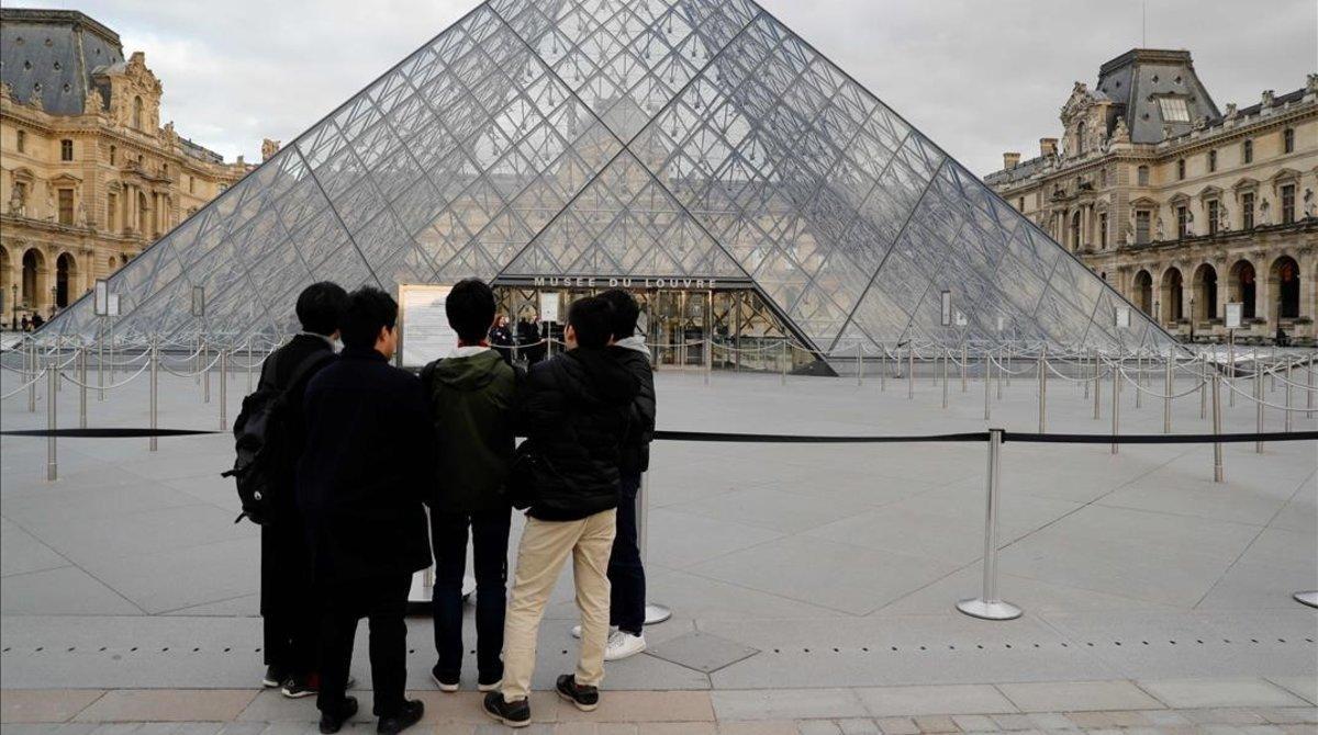 zentauroepp52776727 tourists read an information sign in front of the louvre pyr200313191450