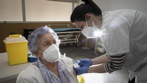 Una mujer de más de 80 años recibe la vacuna de Pfizer contra el covid en Barcelona.