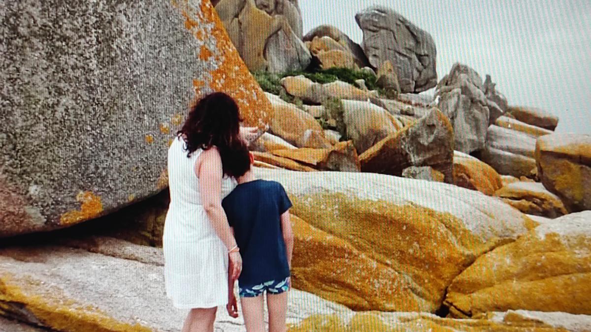 Una madre y su hijo observando las rocas de Rúa.