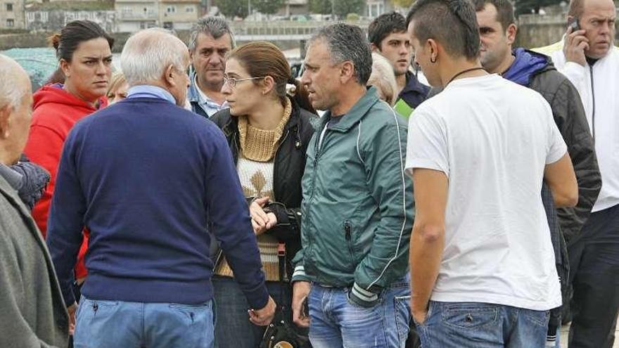 Rosas, de espaldas, con el padre del otro náufrago, en Bueu. // S.A.