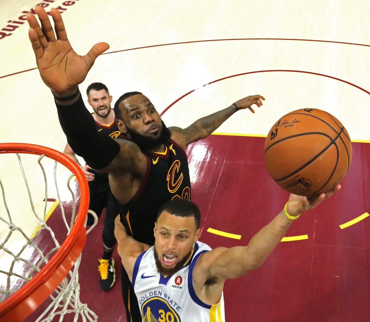 JGM59. CLEVELAND (EE.UU.), 07/06/2018.- Stephen Curry (c) de Golden State Warriors tira a canasta ante la defensa de LeBron James (i) de Cleveland Cavaliers, hoy, miércoles 6 de junio de 2018, durante el tercer juego de las finales de la NBA, en el Quicken Loans Arena de Cleveland, Ohio (EE.UU.). Los Cavaliers disputan hoy contra Golden State Warriors el tercer juego de siete que componen la gran final de la NBA. Los Warriors comandan con los dos primeros partidos ganados. EFE/GREGORY SHAMUS/GETTY IMAGES/POOL/PROHIBIDO SU USO POR SHUTTERSTOCK