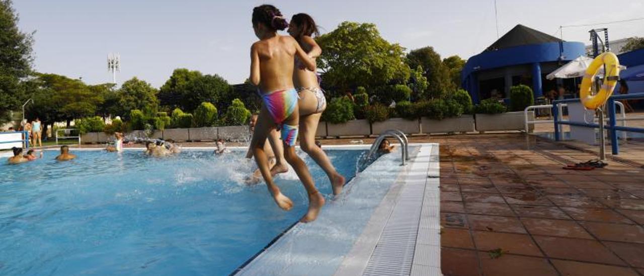 Dos niñas se lanzan al agua en una piscina de Zaragoza.