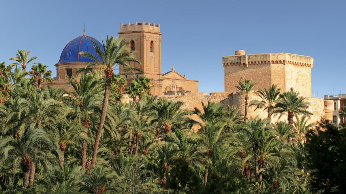 Imagen clásica de Elche con el Palmeral, la basílica de Santa María y el Palacio de Altamira.