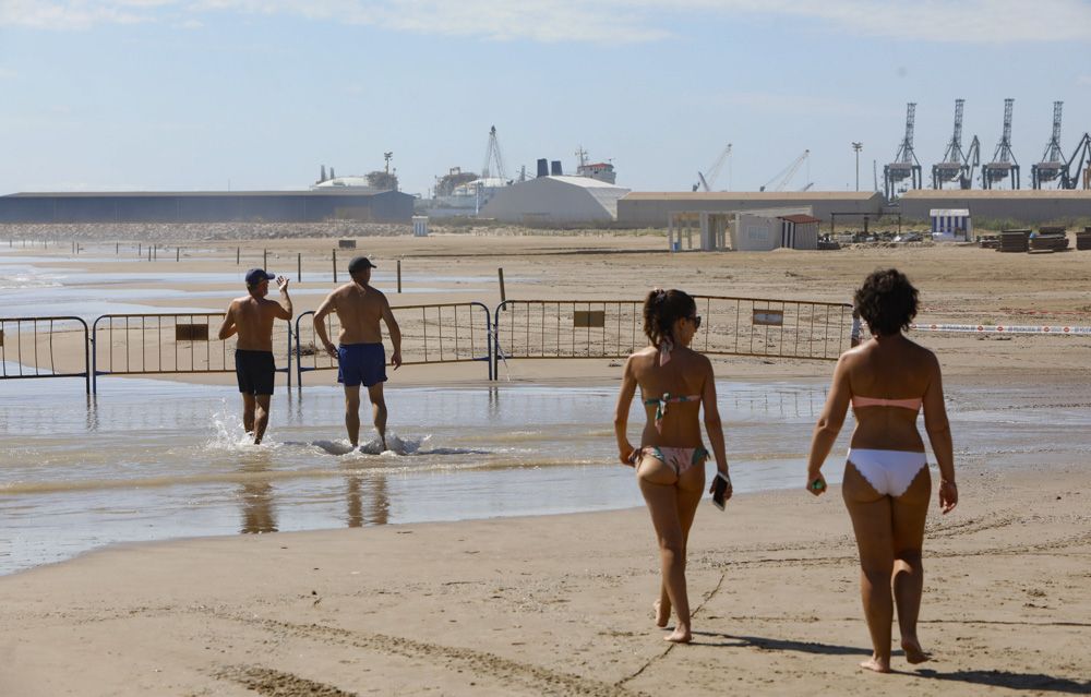 Contraste en la playa del Puerto de Sagunto, con una zona cerrada por los daños de las lluvias.