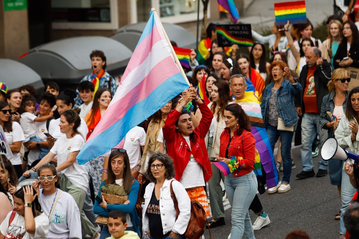 Una persona alza la bandera trans.