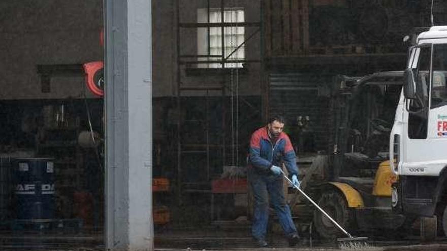 Un empleado limpia la zona del incendio. // Rafa Vázquez