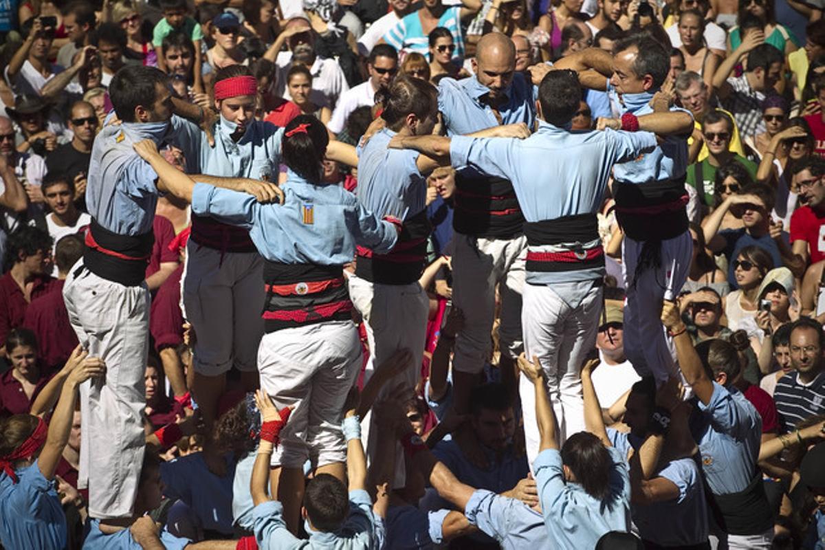 Una de les colles escalfa motors i inicia la base de la seva torre humana, recolzada pel públic congregat davant l’Ajuntament.
