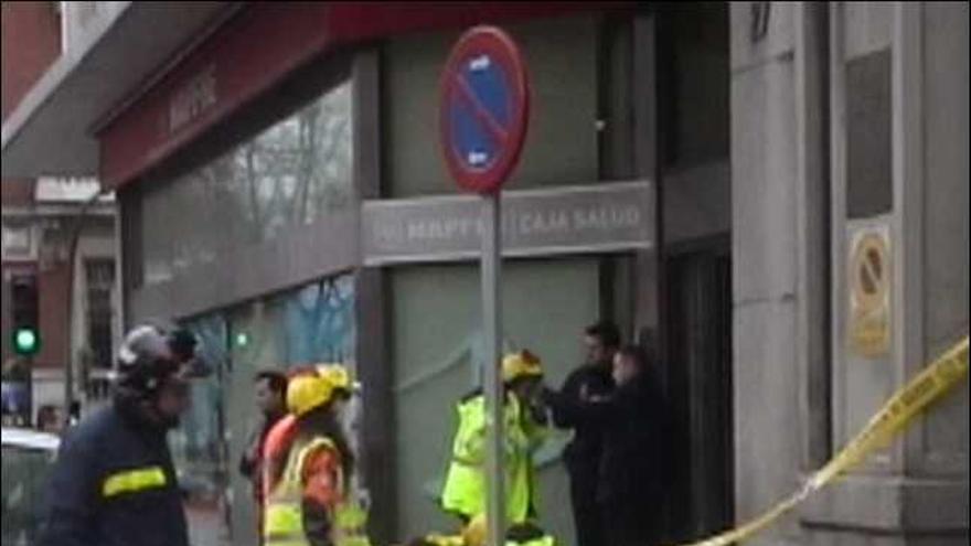 Sanitarios atienden a la mujer que resultó herida de gravedad y luego falleció al caerle encima los cascotes de la fachada de un edificio