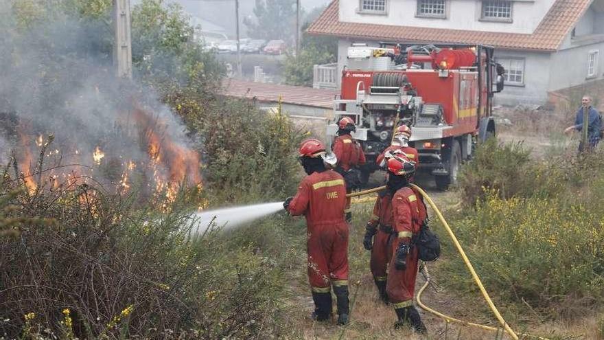 Efectivos de la UME apagan un incendio próximo a viviendas en Pazos de Borbén.