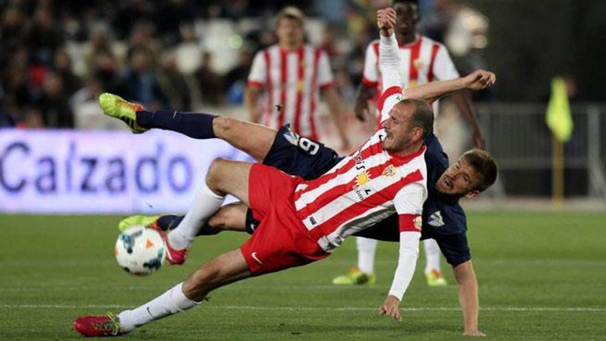 El jugador del Almería Soriano (delante) cae junto a Camacho, del Málaga, durante el partido de Liga en Primera División disputado esta noche en el estadio de los Juegos Mediterráneos, en Almería.