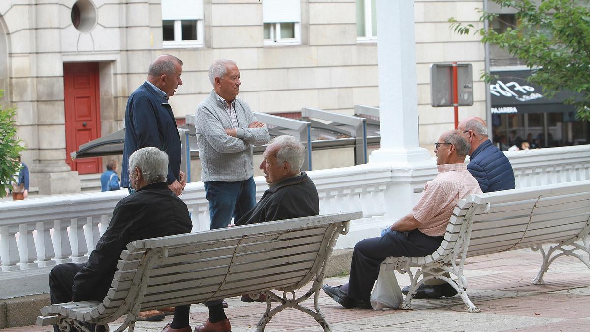 Un grupo de personas mayores charla en la calle, en Ourense