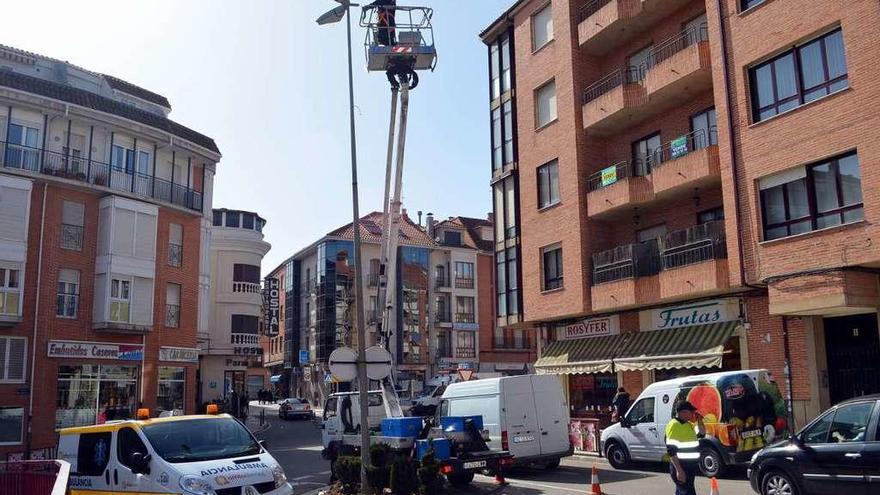 Operarios municipales sustituyendo una luminaria, en la avenida Maragatos.