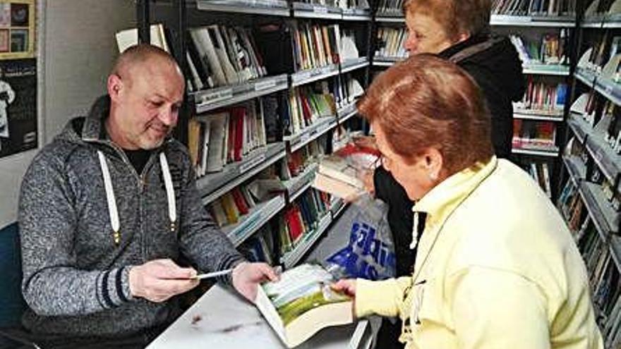 Dos mujeres hacen uso del servicio de bibliobús en un pueblo de Zamora.