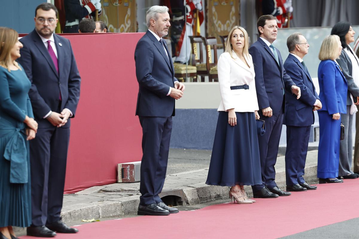 MADRID, 12/10/2025.- El presidente de Aragón, Jorge Azcón (c-izda), y la de Extremadura, María Guardiola (c-dcha), antes de presenciar el desfile de las Fuerzas Armadas con motivo de la Fiesta Nacional en la tribuna de autoridades este domingo. EFE/ Chema Moya