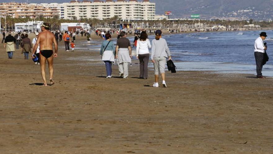 Las altas temperaturas que superan los 20 grados en la ciudad de Valencia han animado a muchos a pasear e incluso a darse un chapuzón, hoy, 1 de enero del 2012, en la playa de la Malvarrosa.