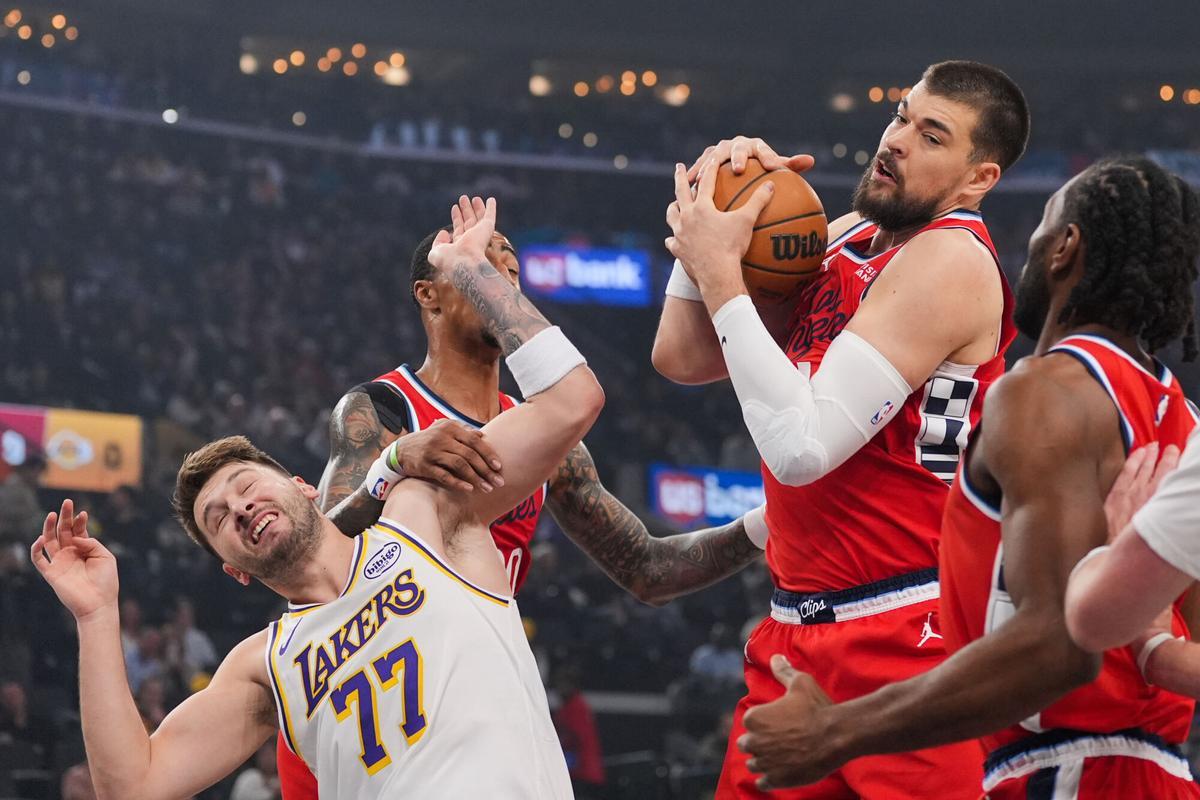 Los Angeles Clippers center Ivica Zubac, left, gets a rebound against Los Angeles Lakers forward/guard Luka Doncic during the first half of an NBA basketball game Saturday, Dec. 20, 2025, in Inglewood, Calif. (AP Photo/Jae C. Hong)