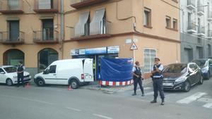 Agentes de los Mossos custodian la puerta de un locutorio de Ripoll registrado en relación con los atentados de Barcelona y Cambrils.