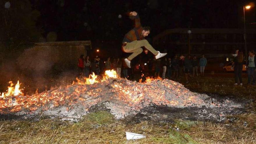 Un joven salta la fogata en A Bandeira. Izquierda, asistentes a la fiesta de Campo de Arriba. // Bernabé/Javier Lalín