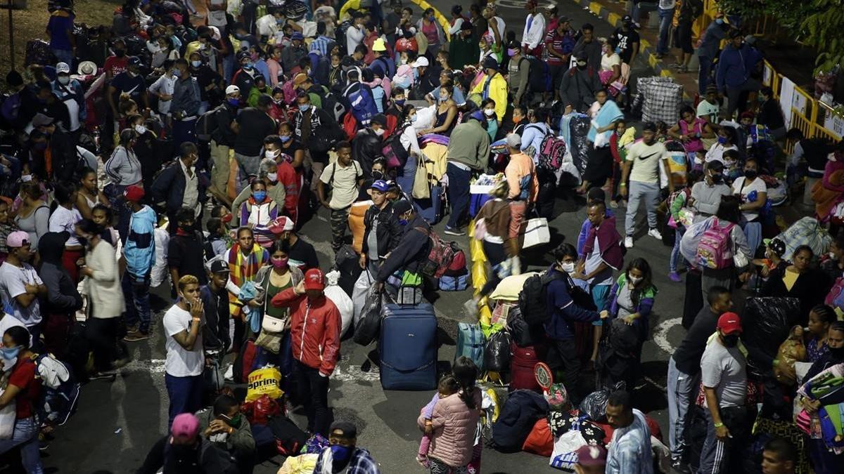 Decenas de migrantes venezolanos esperan en Cali un transporte para regresar a su país debido a la crisis del coronavirus.