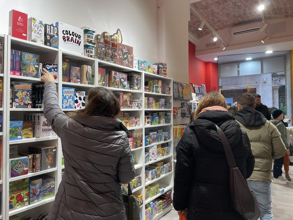 Diversos compradors buscant jocs a la botiga La Juganera, a Girona