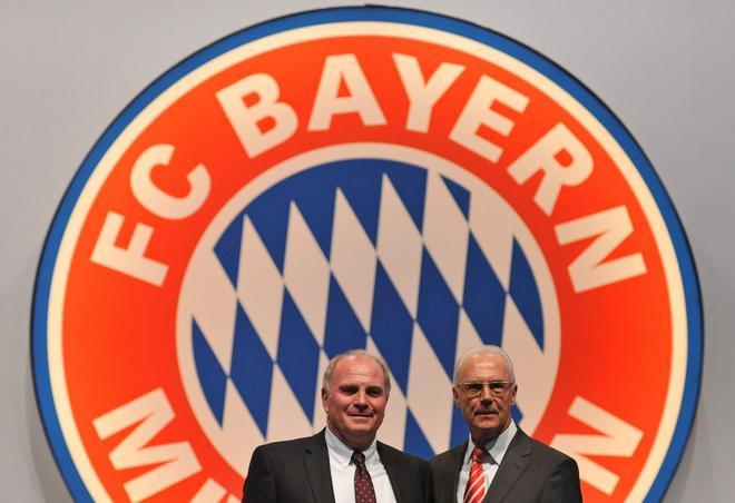 El mánager del Bayern de Munich Uli Hoeness y su presidente Franz Beckenbauer en 2009, frente a un logo del club en Munich