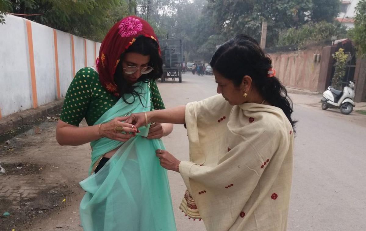 Una mujer de Varanasi ayuda a Ángela García con el sari. | A.G.R.