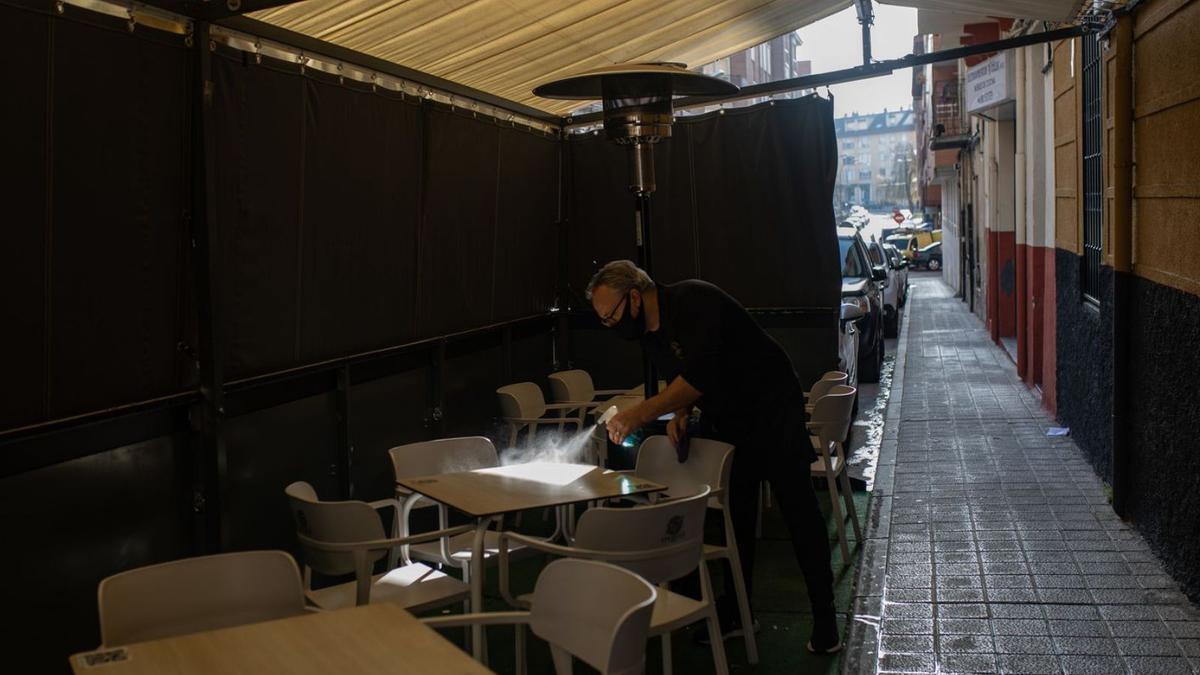El responsable de un establecimiento limpia una de las mesas de su terraza. | Emilio Fraile