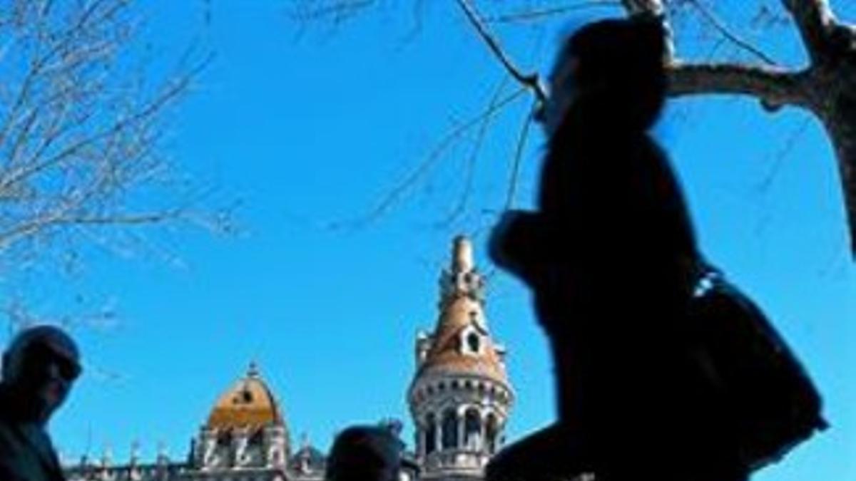 Siluetas de varias personas caminando por el paseo de Gràcia.