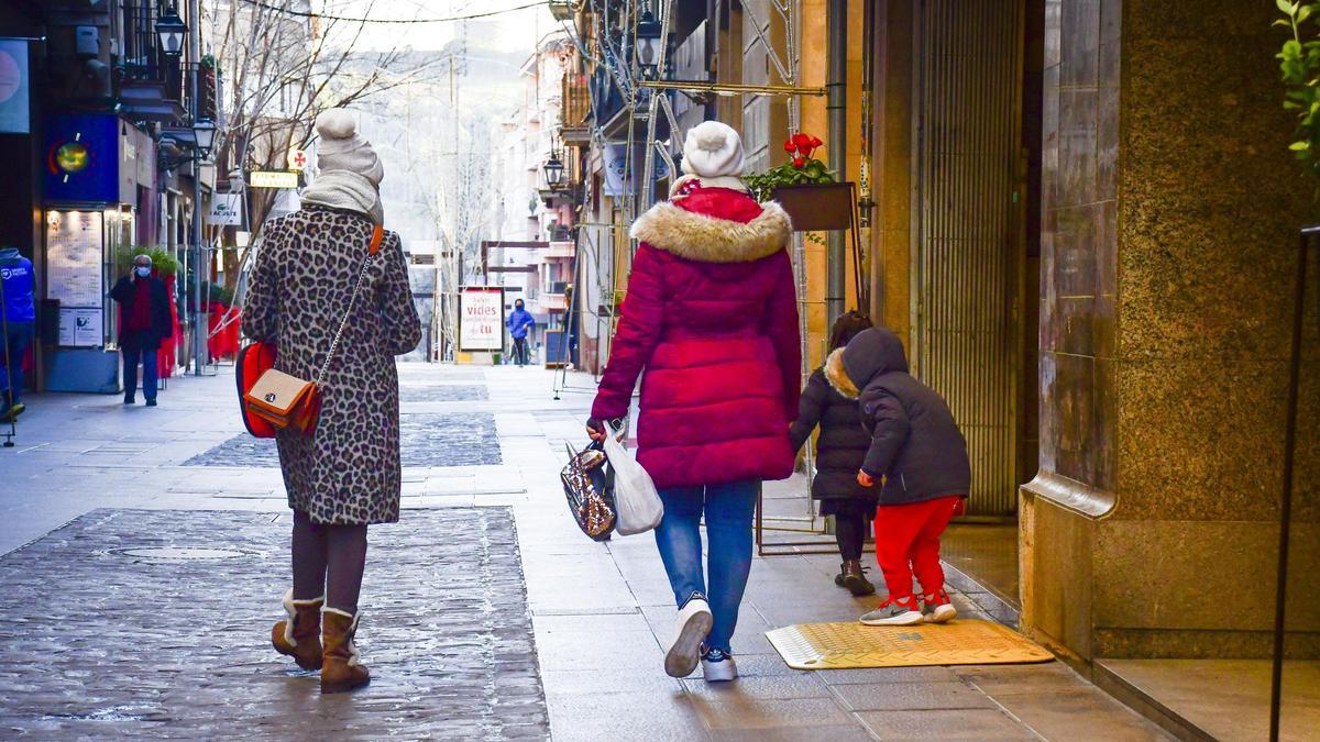 Gent passejant abrigada pel centre de Manresa