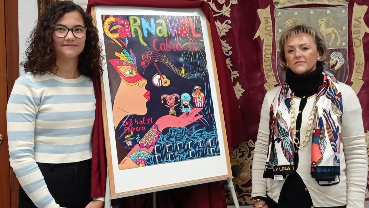 Eugenia Garrido y Rosario Lama muestran el cartel del Carnaval de Cabra.