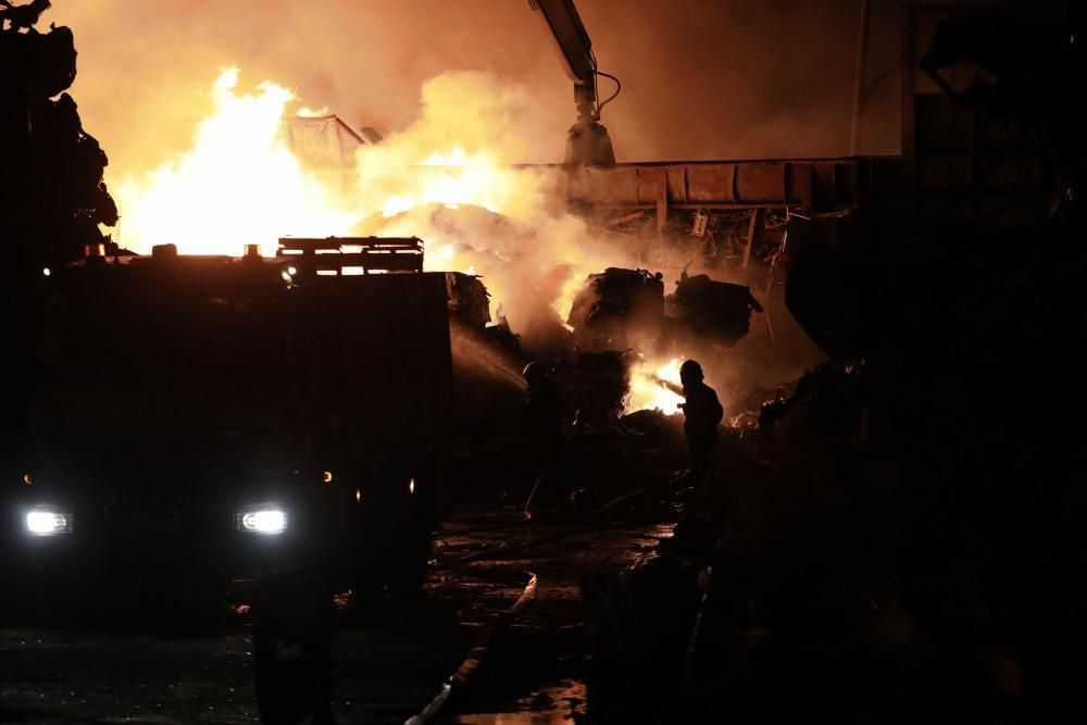 Labores de extinción del incendio de un desguace en Gijón